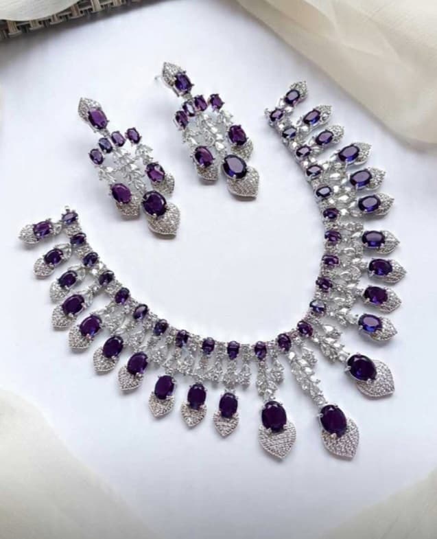 Jewelry set with necklace and earrings featuring purple stones

Details