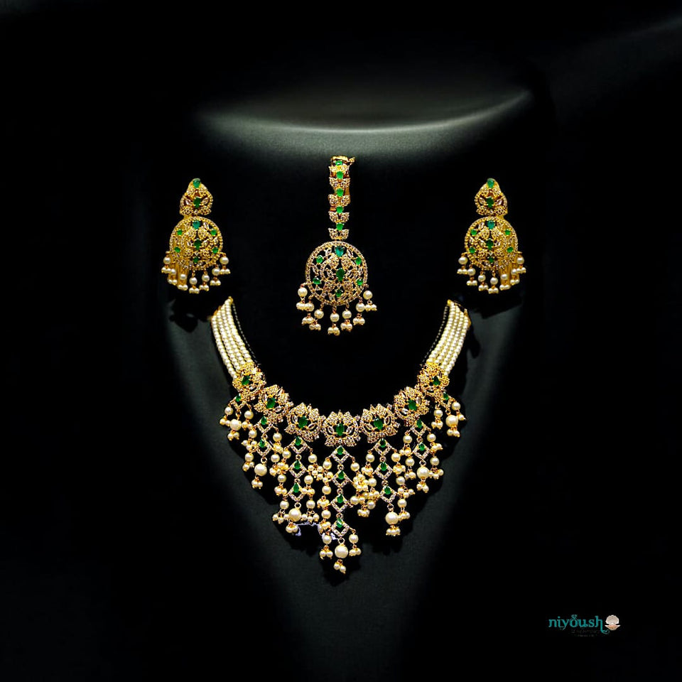 Gold necklace and earrings set with green gemstones 